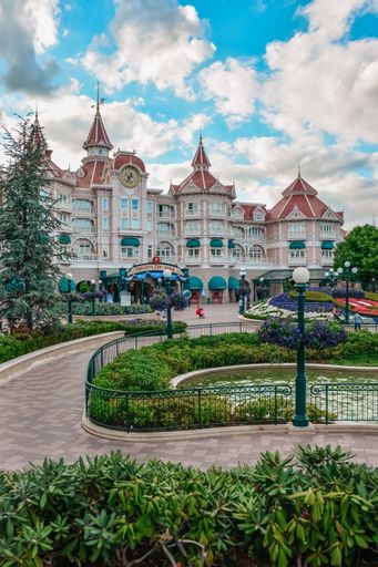 A vertical shot of Disneyland in Paris with colorful walls' buildings, and green plants over the roads