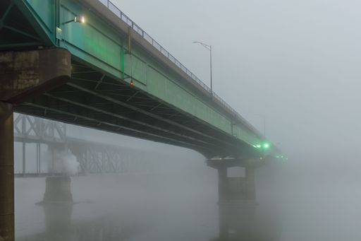 A road bridge fading into the heavy fog over the Missouri river