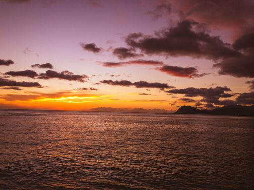 A dramatic sunset in the horizon over the calm sea