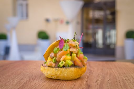 A closeup shot of a salmon tartare appetizer on the wooden table