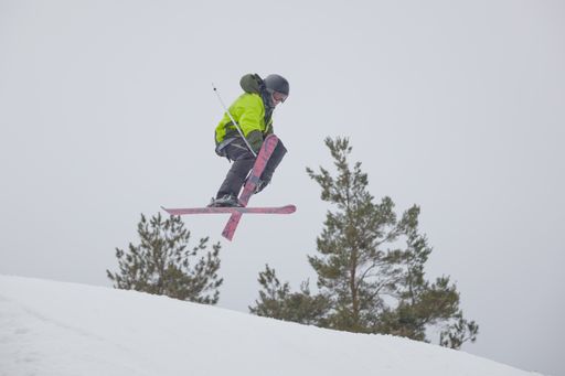 A snowboarder jumping high through the air at the Wisp Ski Resort in Deep Creek Lake Maryland