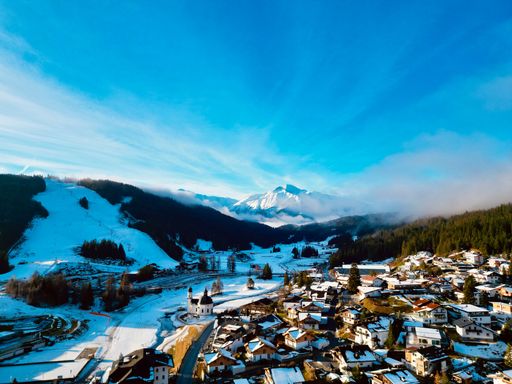 An aerial view of snowy mountains near houses in Seefeld, Tirol, Austria