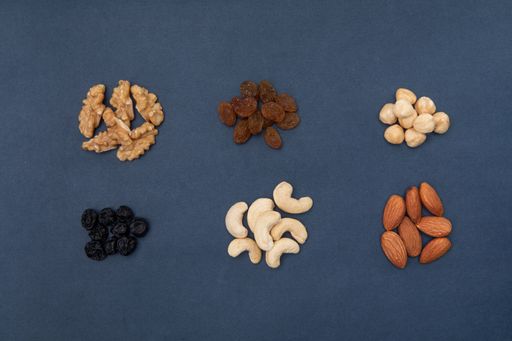 A high angle shot of piles of nuts and seeds on a blue surface
