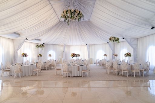 The wedding tables in the restaurant hall with beautiful floral decorations.
