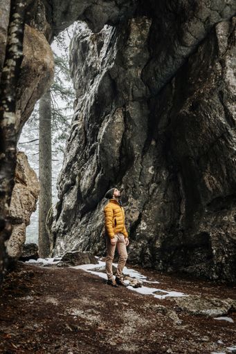 A vertical shot of a Caucasian male hiking in a cave