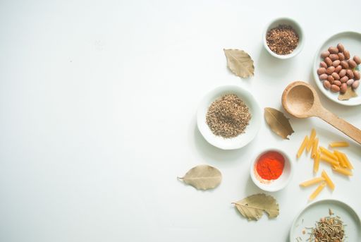 A top view of colorful spices, beans, dry pasta on a white background with copy space.