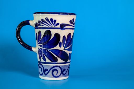 A Talavera cup isolated in the blue background with a copy space