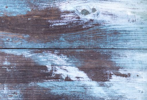 Aged wooden planks background texture with white and blue peeling paint. Full frame