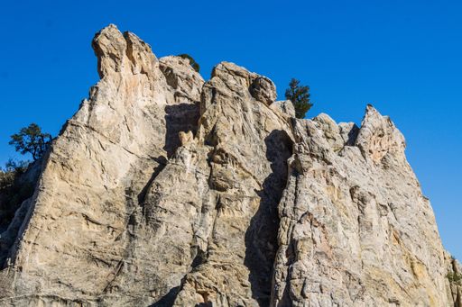 An aerial view of rugged rock formations majestically against a pristine blue sky in Colorado