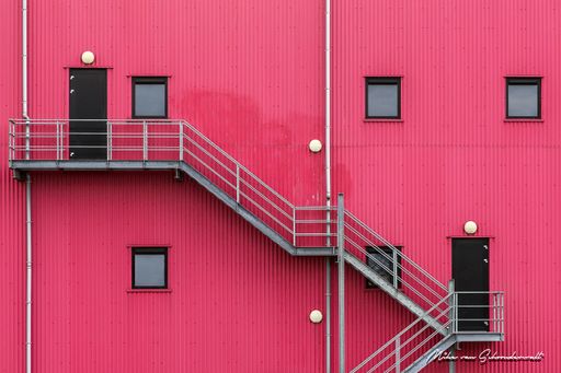 A pink building with stairs on the side