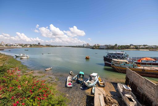 A high angle shot of the Mombasa waterfront on a sunny day with small boats and ships