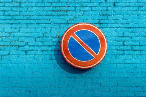 A no waiting sign on a blue brick wall