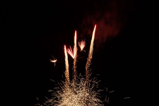 A scenic view of red and golden fireworks shining in the night sky