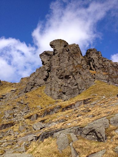 A vertical shot of cliffs near lake Tekapo in New Zealand with cloudscape in the background