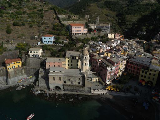 An aerial shot of the town of Vernazza with colorful waterfront buildings in Italy