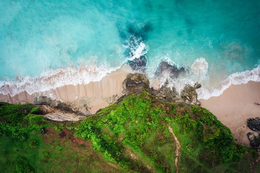 Aerial view of a pristine beach and turquoise ocean, with a unique perspective from above