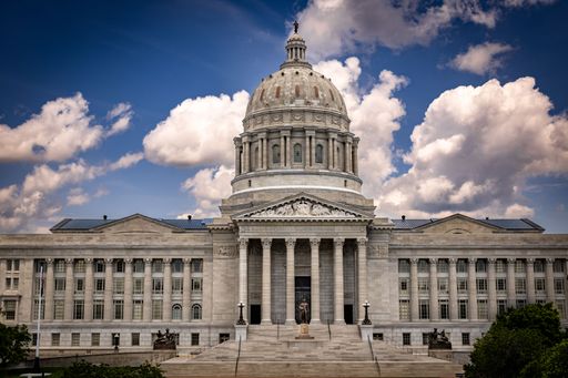 The mesmerizing Missouri State Capitol building with stairs and a statue in the front under the blue sky in Jefferson City