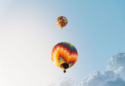 A low-angle shot of the colorful hot air ballons flying in the blue sky