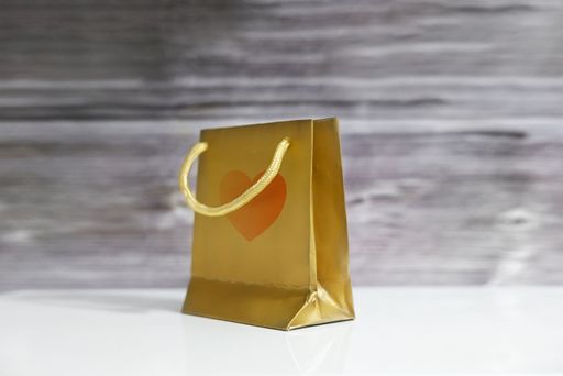 A golden handbag set atop a polished wooden table against a neutral background