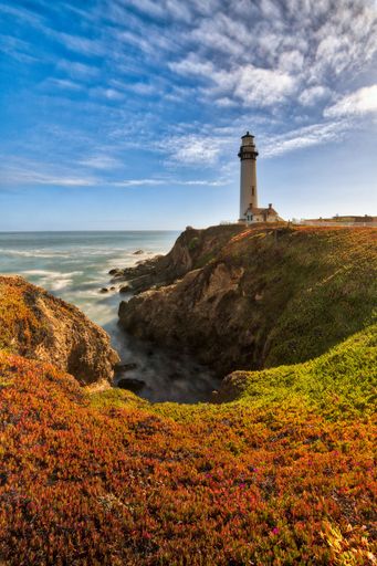 A vertical shot of a beautiful lighthouse near the sea