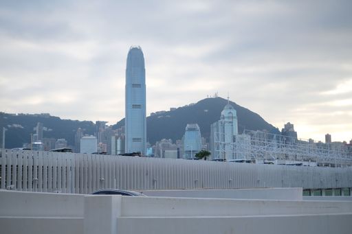 The Victoria Harbor in Hong Kong building with towers under cloudy sky at sunset