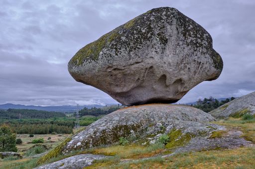 A closeup of outcrops covered in mosses and grass under a cloudy sky in Portugal