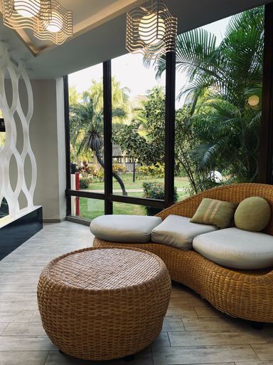 This cozy living room features wicker seating with throw pillows and warm lighting