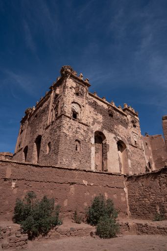 A low-angle vertical shot of the ancient castle against a blue sky