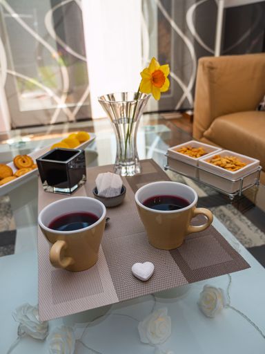 A vertical shot of snacks and coffee mugs on a table