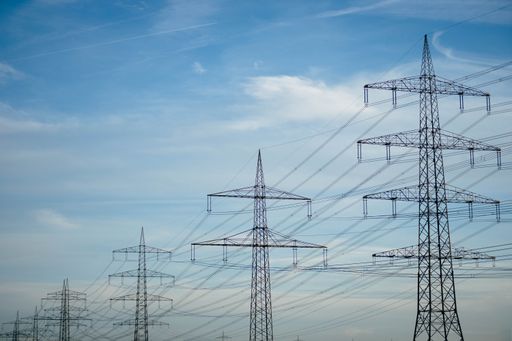 Many power poles in a row under blue sky. The cables conduct the electricity and energy in the energy crisis. Electricity becomes more expensive.