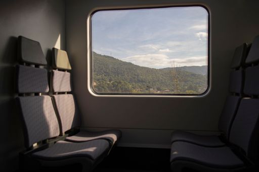 A train with empty seats with a view on mountains outside of a window