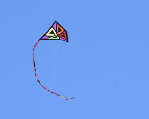 A colorful kite flying in the blue sky with a copy space