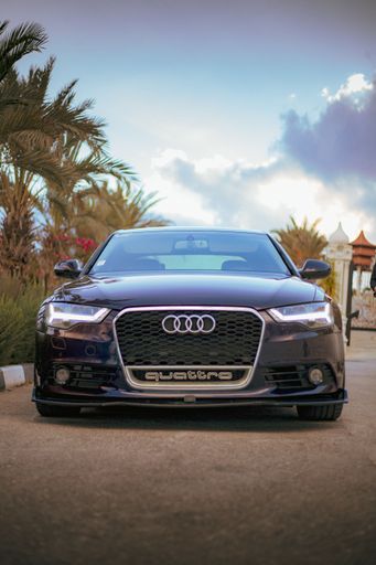 A vertical shot of a luxurious purple sport Audi a6 car on a road