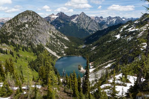 A high angle shot of a lake in a mountainous region on a cloudy day
