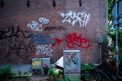 A brick wall with colorful graffities in Amsterdam street