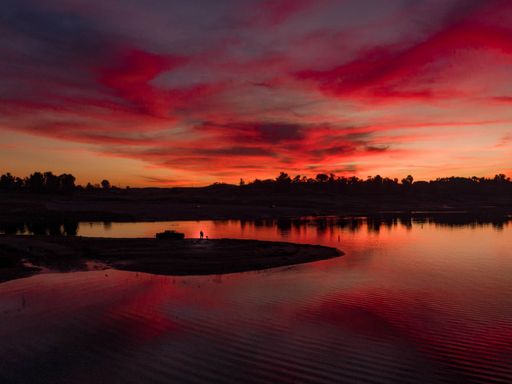 A red sunset over a lake with a small island in the middle