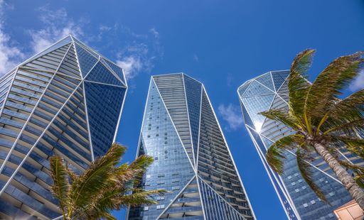 A low angle shot of high-rise skyscrapers, apartments, and palm trees, Australia