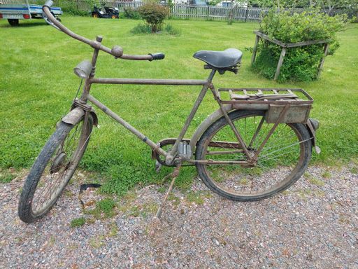 A closeup shot of an old bcicyle parked near the road