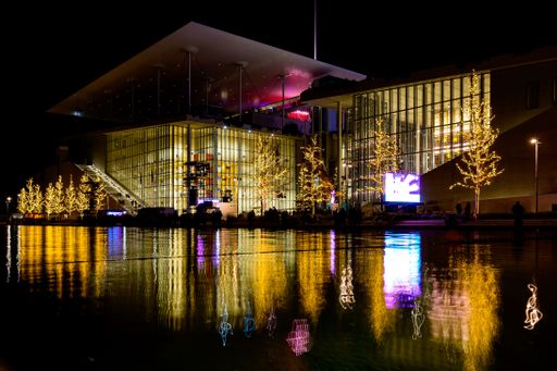 The Stavros Niarchos Foundation in Athens, Greece with Christmas trees reflected in water at night