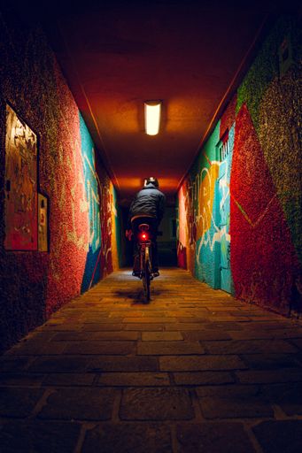 The Biker moving along the corridor with graffities at night