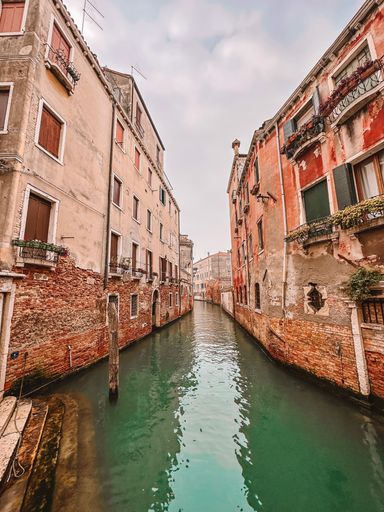 A low angle shot of a canal in the middle of the buildings