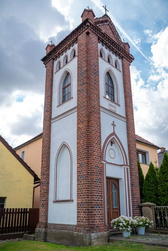 A vertical shot of a traditional chapel with a bell tower by the road in Silesia, Poland