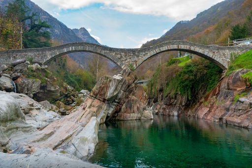 A scenic view of a bridge in the Verzasca Valley, Switzerland in the autumn season