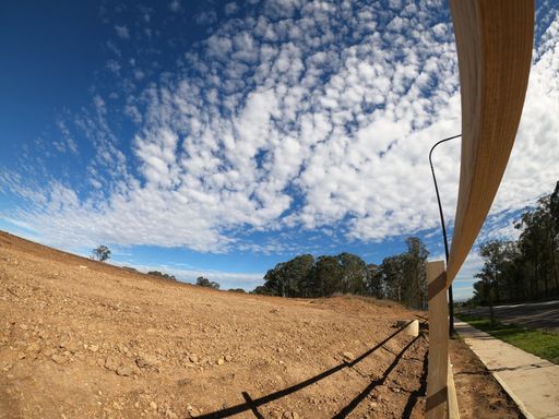 A beautiful view of a road with a wooden fence in Schofield, New South Wales, Australia