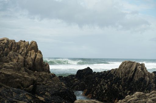 A landscape view of the rocky formations in the sea with large waves