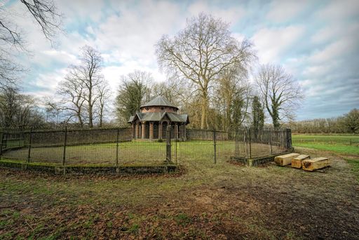 View on the old hunting dog enclosure of Poeke castle, near Poeke in the Belgian province of East Flanders, surrounded by trees, on a cloudy day