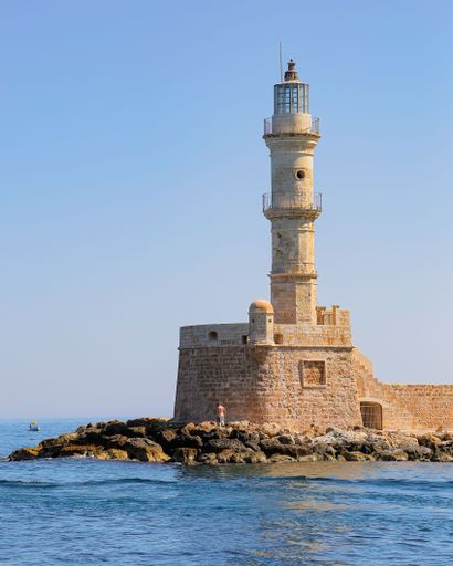 An Old Town Chania tower surrounded by the ocean and sky in Greece