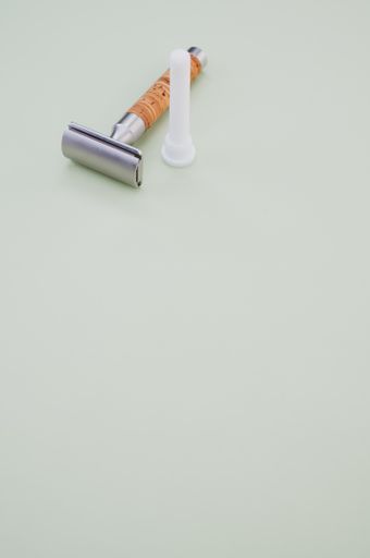 A vertical shot of an old razor on a blue surface