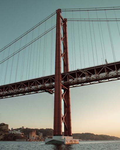 A vertical shot of the 25 de Abril suspension bridge in Lisbon, Portugal under a clear sky