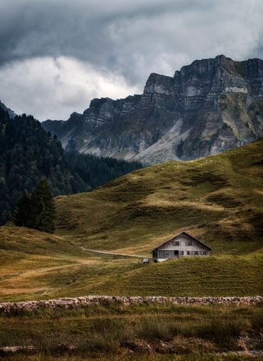 A vertical shot of a house with the Vorarlberg mountains in the background,  Austria